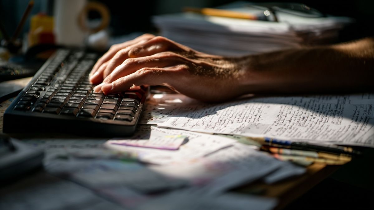 Mains tapant sur clavier entouré de cartes de vocabulaire français